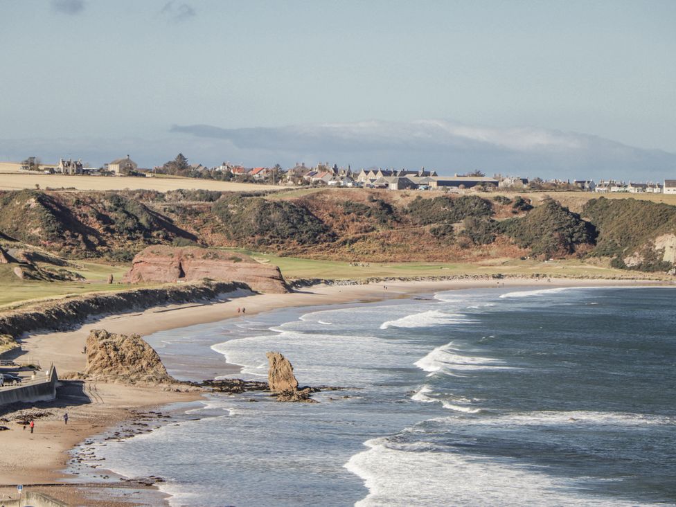 A beach with waves and rock formations along the coast at 83 Seatown Cullen
