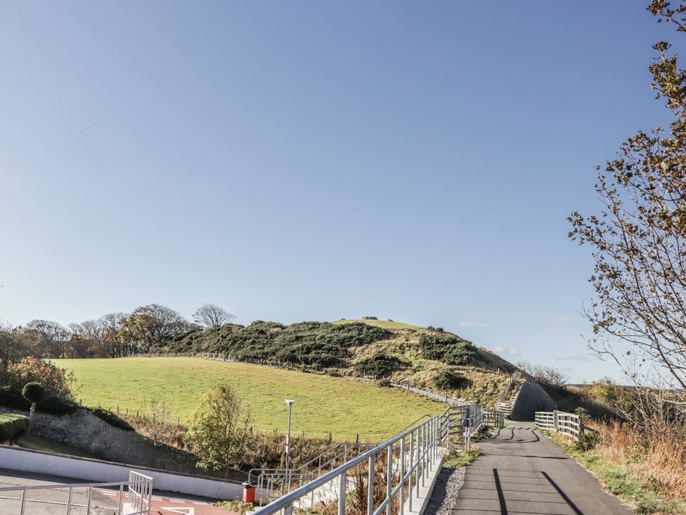 A pathway leading to a hill with trees and grass at 83 Seatown in Cullen