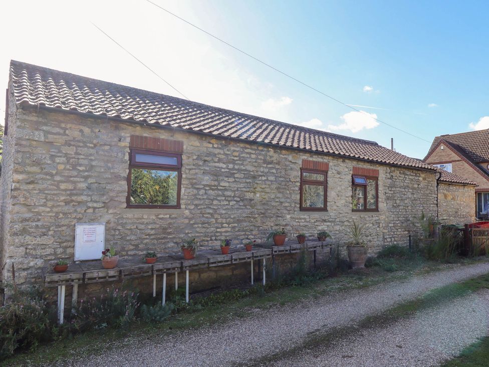 An exterior view of a stone building with gardening pots at The Barn in Snitterby