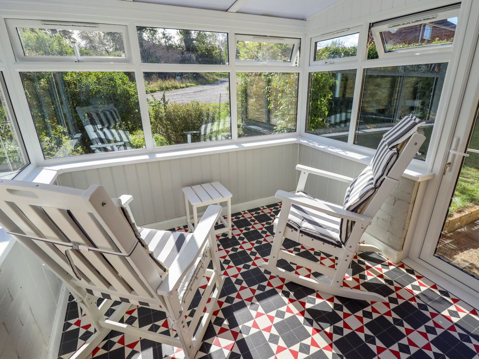 A conservatory with two armchairs and a small table at The Barn Snitterby