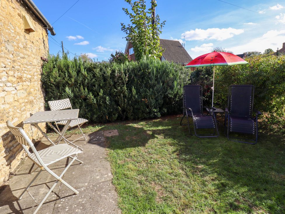 A garden with table, chairs and umbrella at The Barn in Snitterby