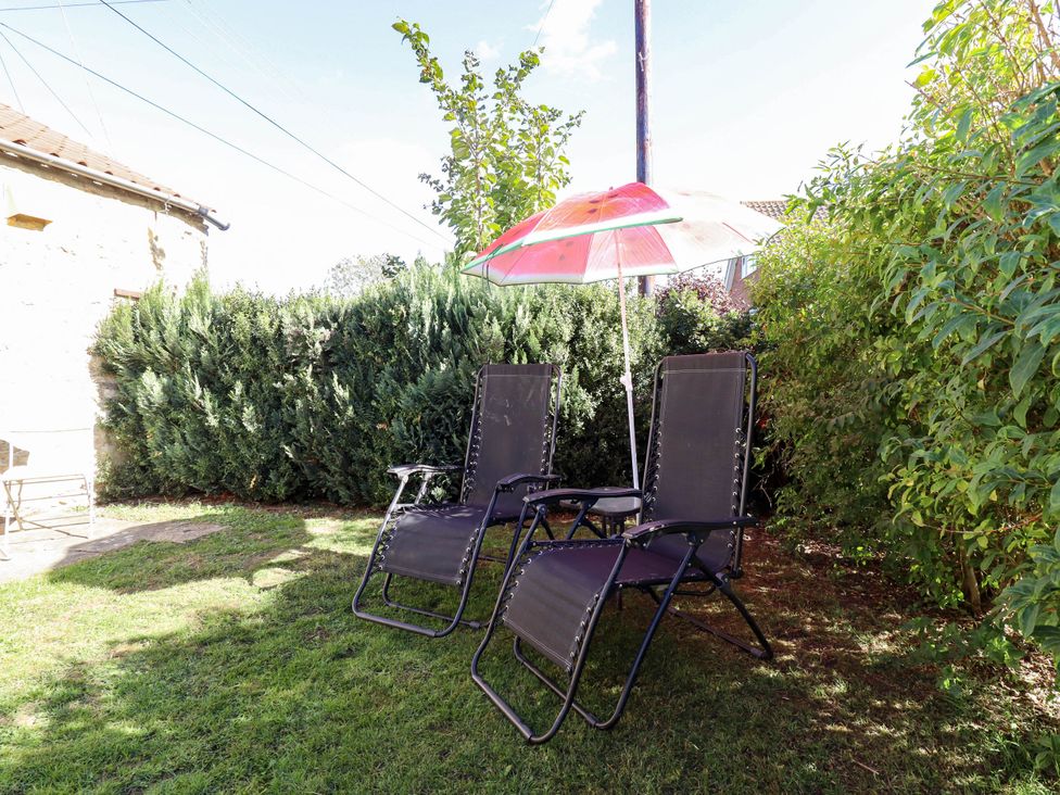 Two chairs under an umbrella in a garden at The Barn Snitterby