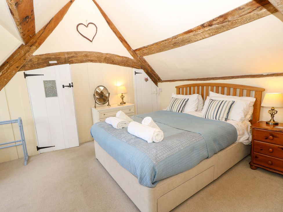 A bedroom with a bed and wooden beams at Tovah in Yarmouth