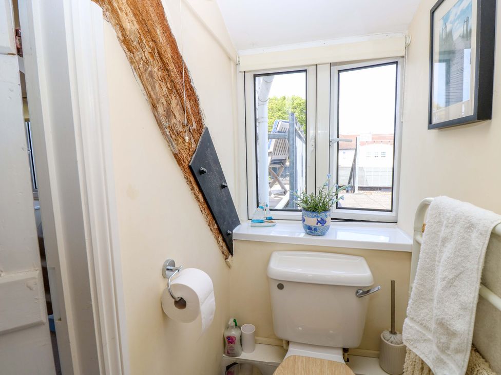 A bathroom with a toilet and window at Tovah, Yarmouth