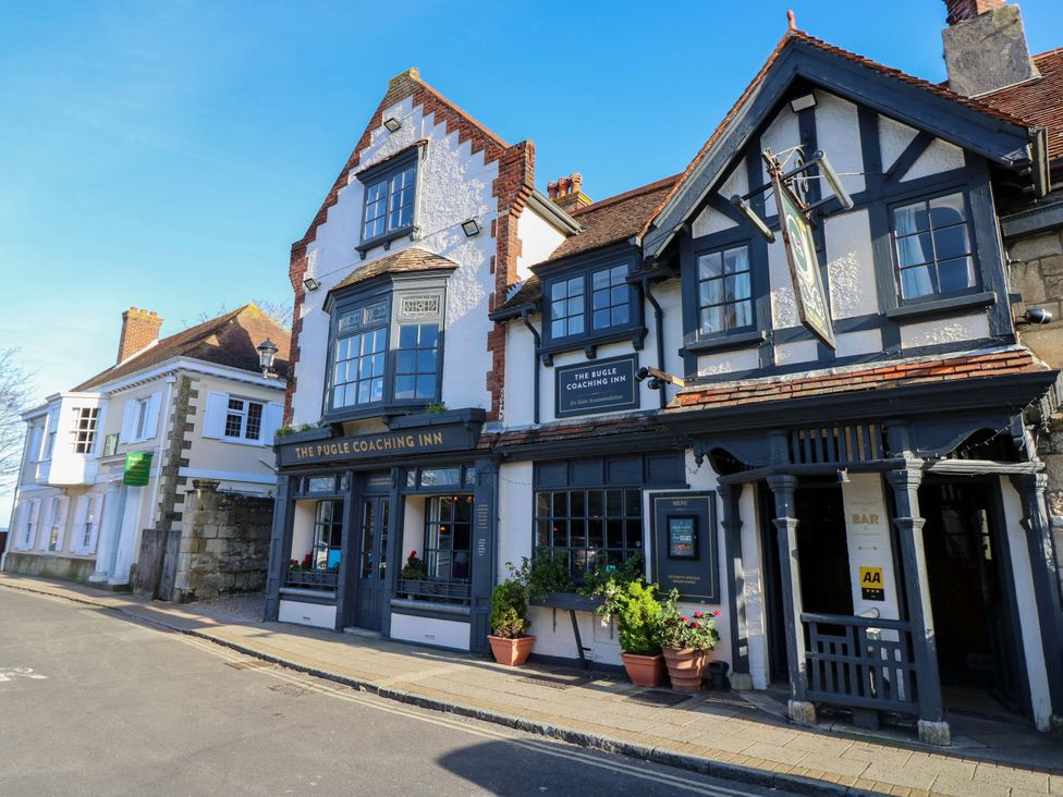 A pub exterior with signs and planters at The Pugle Coaching Inn in Yarmouth