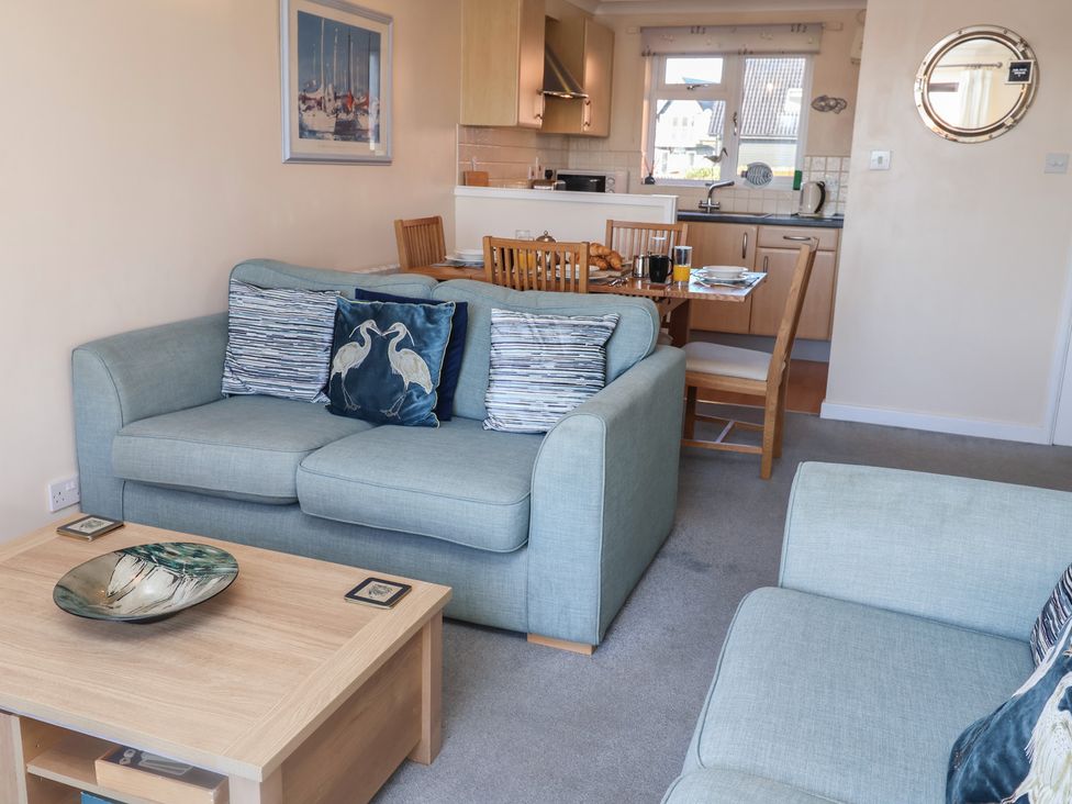 A living room with a sofa and dining area at Daisy Lodge in Norwich