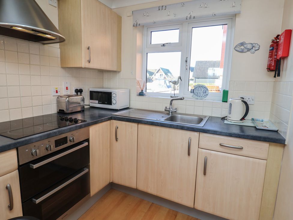 A kitchen with appliances and sink at Daisy Lodge in Norwich