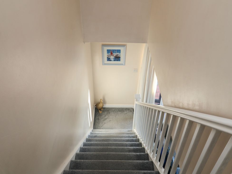 A staircase with a painting on the wall at Daisy Lodge in Norwich