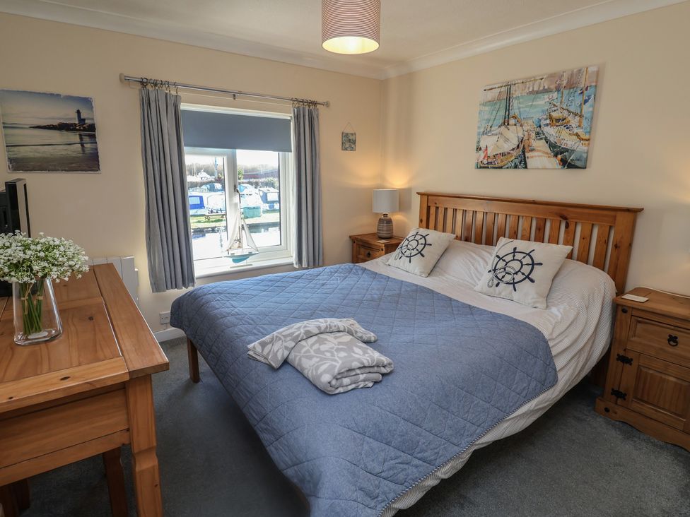 A bedroom with a bed and a desk at Daisy Lodge in Norwich