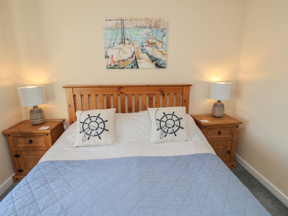 A bedroom with a bed and bedside tables at Daisy Lodge in Norwich