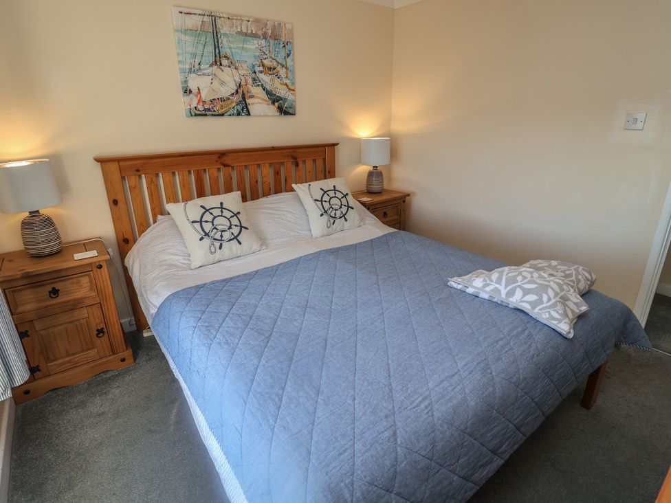 A bedroom with a bed and bedside table at Daisy Lodge in Norwich