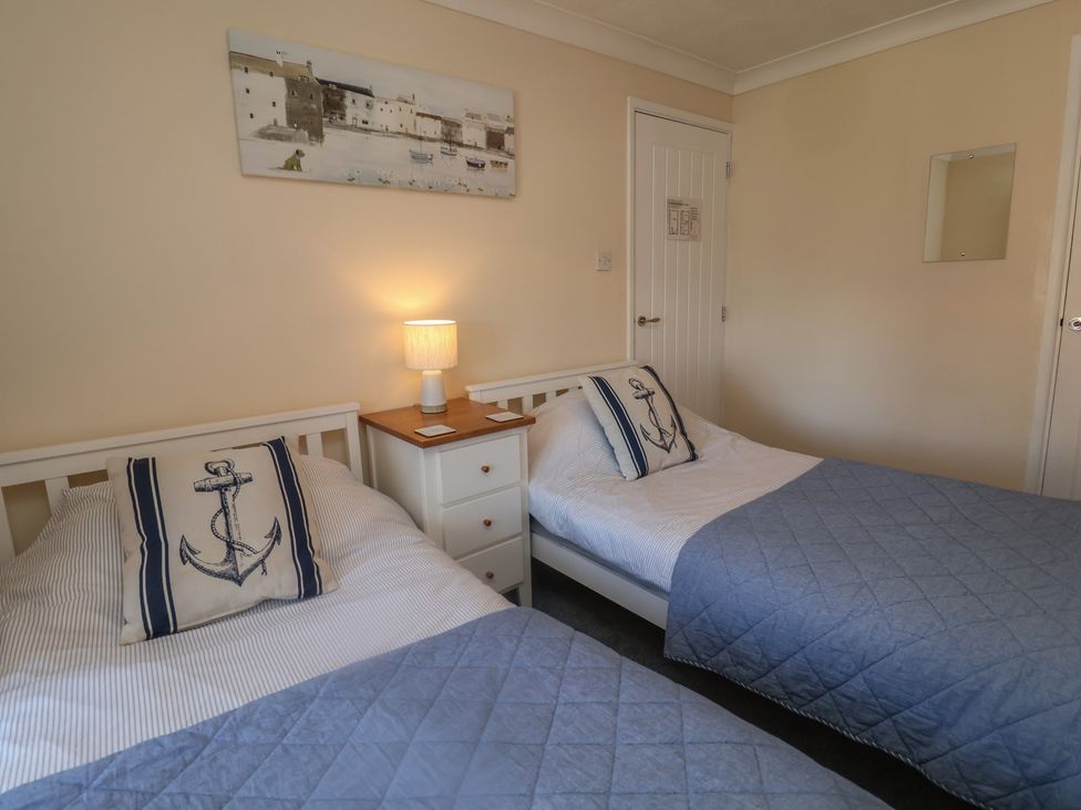 A bedroom with two single beds and a nightstand at Daisy Lodge in Norwich