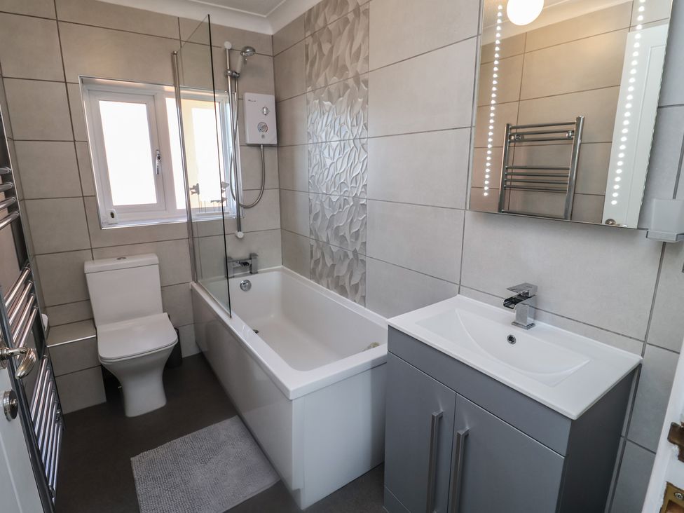 A bathroom with a bathtub, toilet, and sink at Daisy Lodge in Norwich