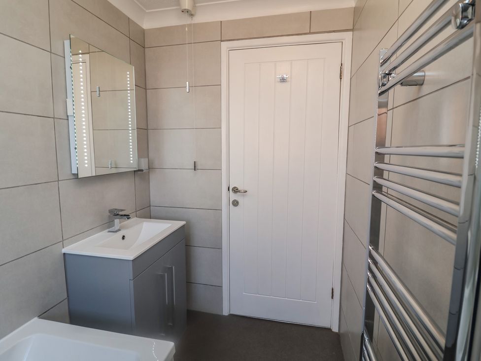 A bathroom with a sink and mirror at Daisy Lodge in Norwich
