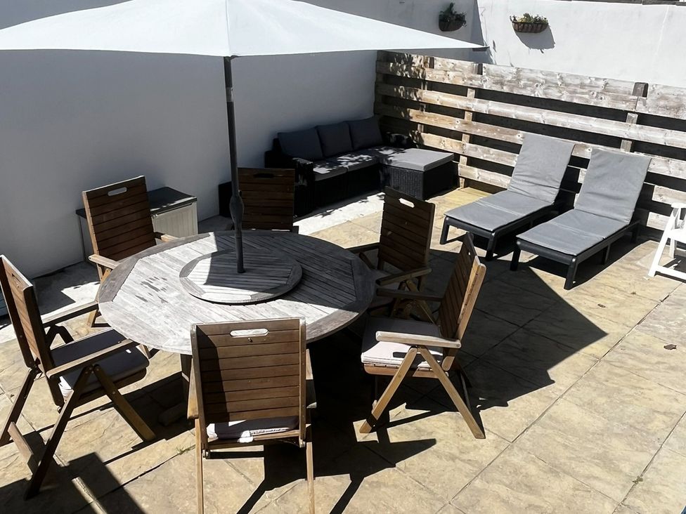 An outdoor seating area with a table and chairs at 8 Harlyn Mews, Harlyn Bay, Cornwall