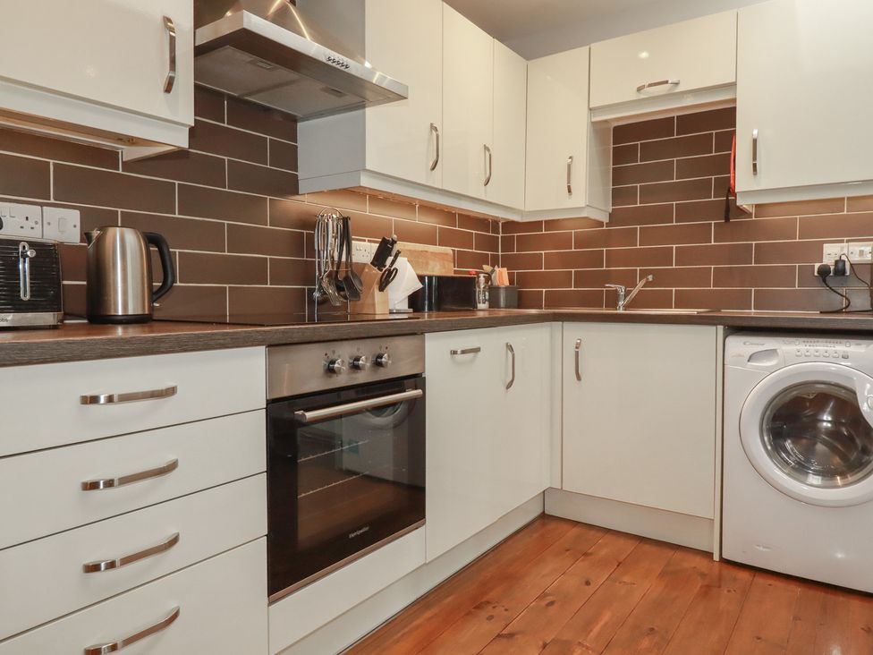 A kitchen with an oven and washing machine at The Smithy in Blisland