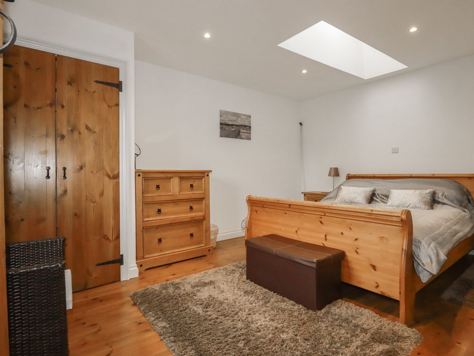 A bedroom with a bed and wooden furniture at The Smithy in Blisland