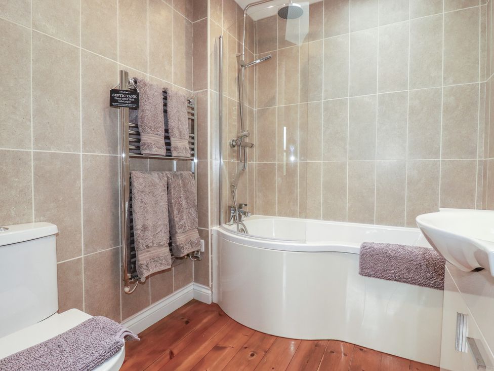 A bathroom with a bathtub, toilet, and sink at The Smithy in Blisland