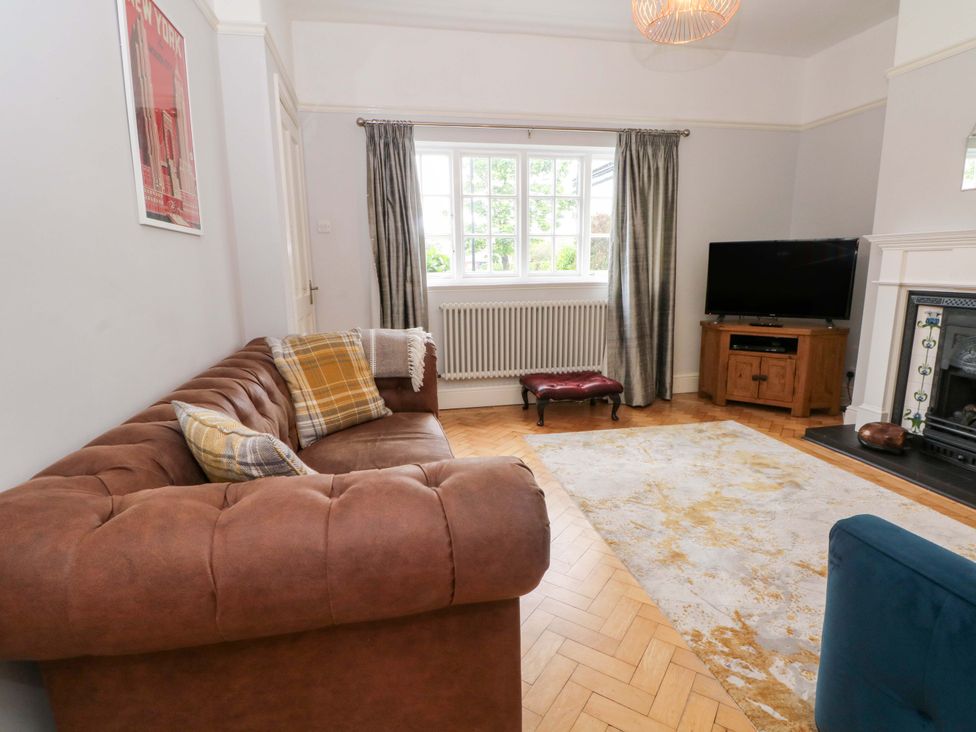 A living room with a sofa and television at Sunlight Soap Cottage in Port Sunlight