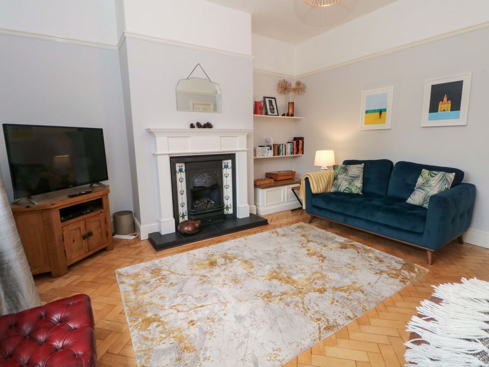 A living room with a sofa and television at Sunlight Soap Cottage in Port Sunlight