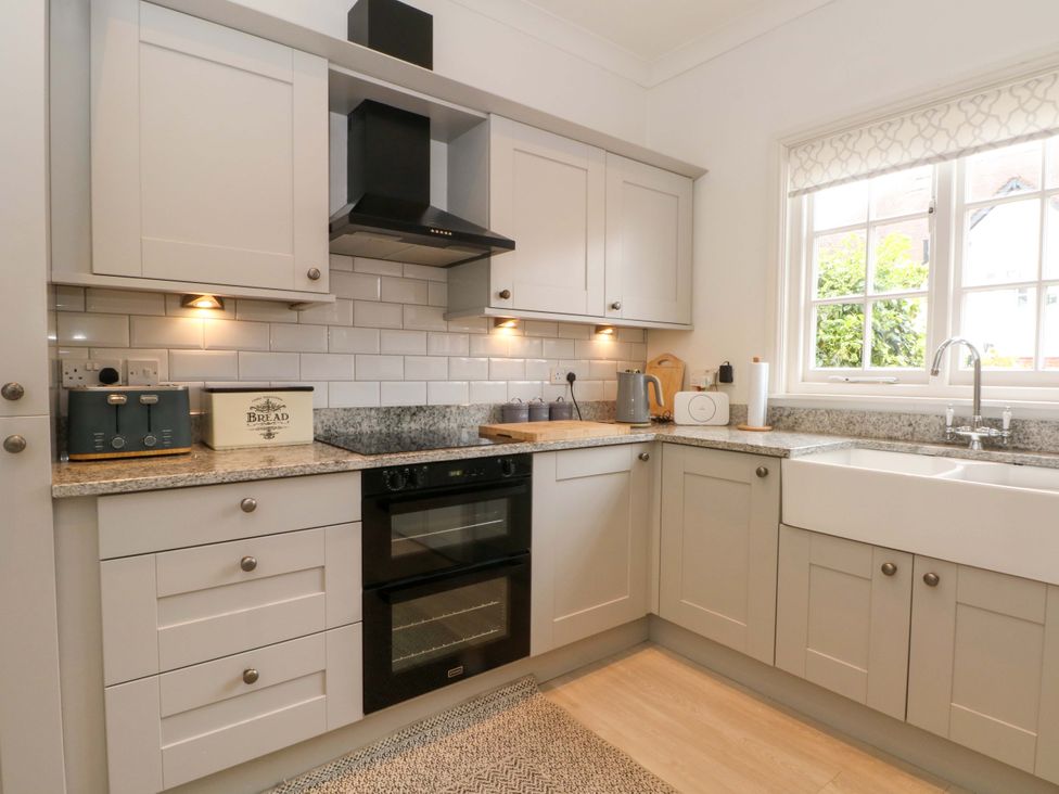 A kitchen with cabinets, oven, sink, and appliances at Sunlight Soap Cottage in Port Sunlight