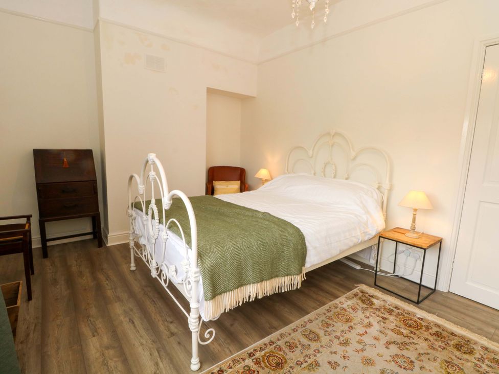 A bedroom with a bed and a nightstand at Sunlight Soap Cottage in Port Sunlight