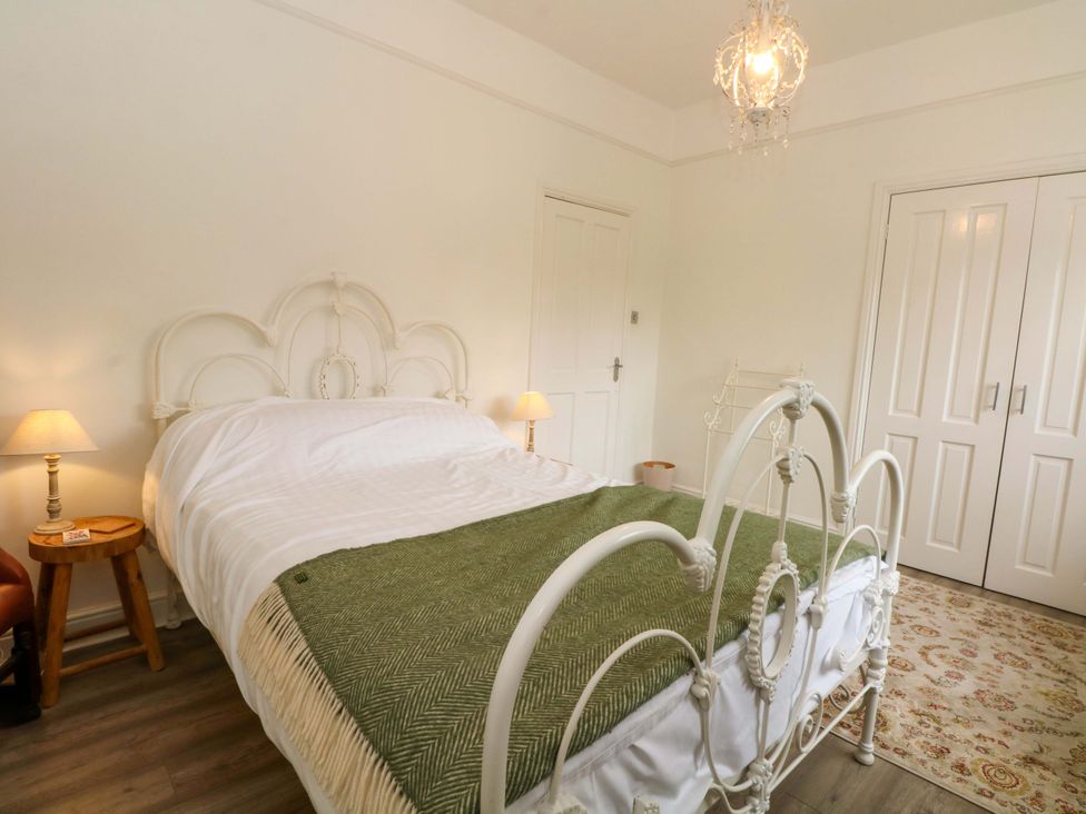 A bedroom with a bed and wardrobe at Sunlight Soap Cottage in Port Sunlight