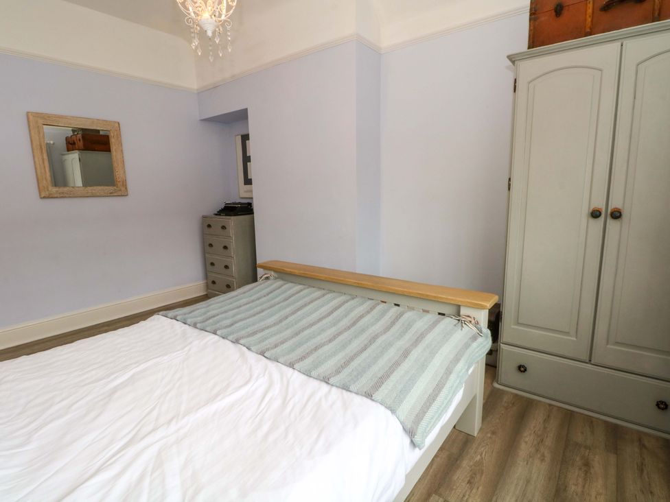 A bedroom with a bed and wardrobe at Sunlight Soap Cottage in Port Sunlight