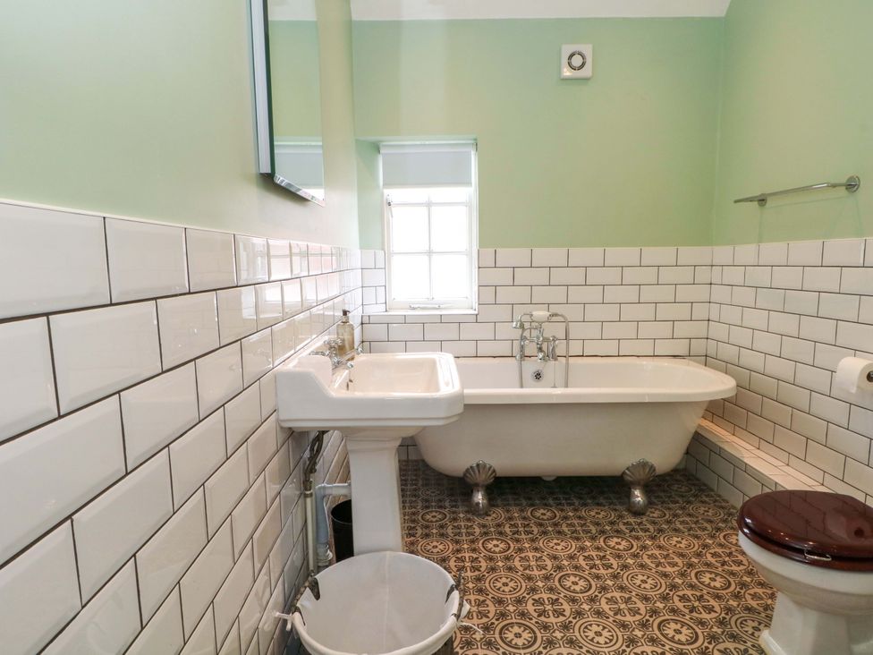 A bathroom with a bathtub, sink, and toilet at Sunlight Soap Cottage in Port Sunlight