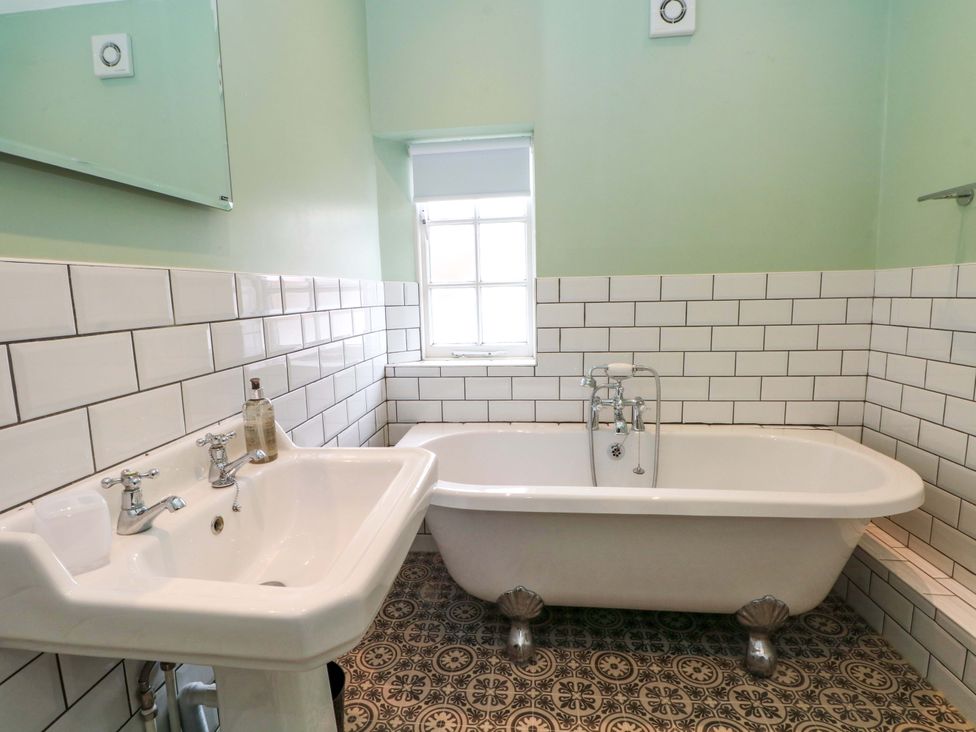 A bathroom featuring a bathtub and sink at Sunlight Soap Cottage Port Sunlight