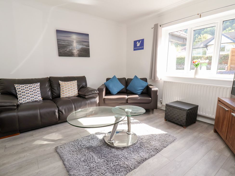 A living room with a coffee table and two sofas at Talgais Llangollen