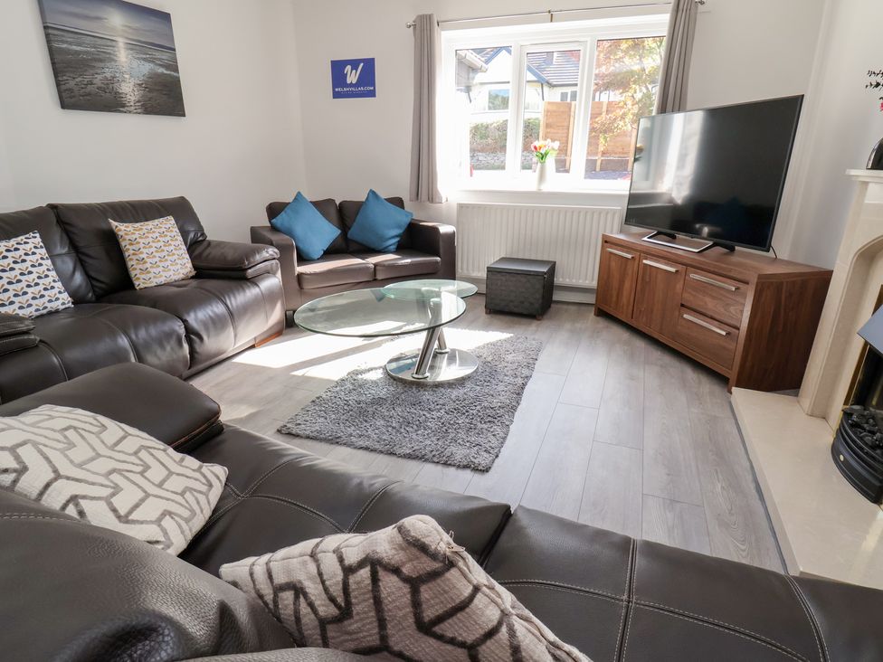 A living room with a sofa, coffee table, and television at Talgais in Llangollen