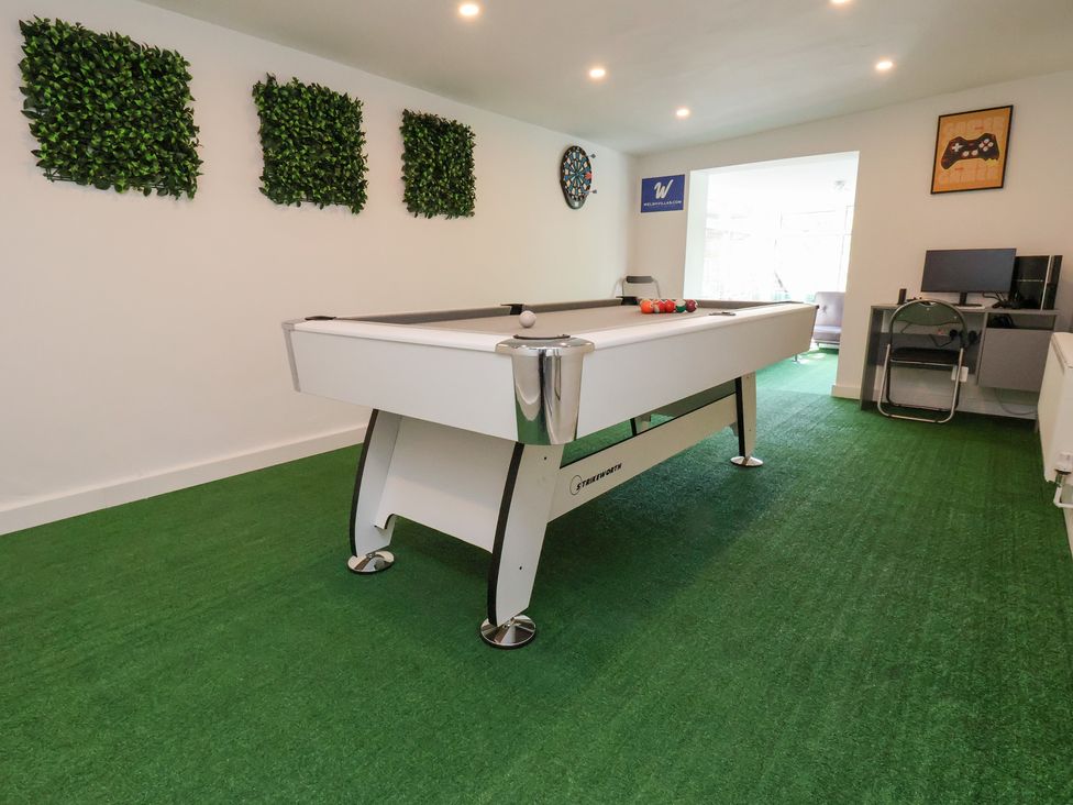 A game room with a pool table and dartboard at Talgais in Llangollen