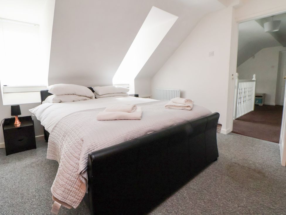 A bedroom with a bed and bedside table at Talgais in Llangollen