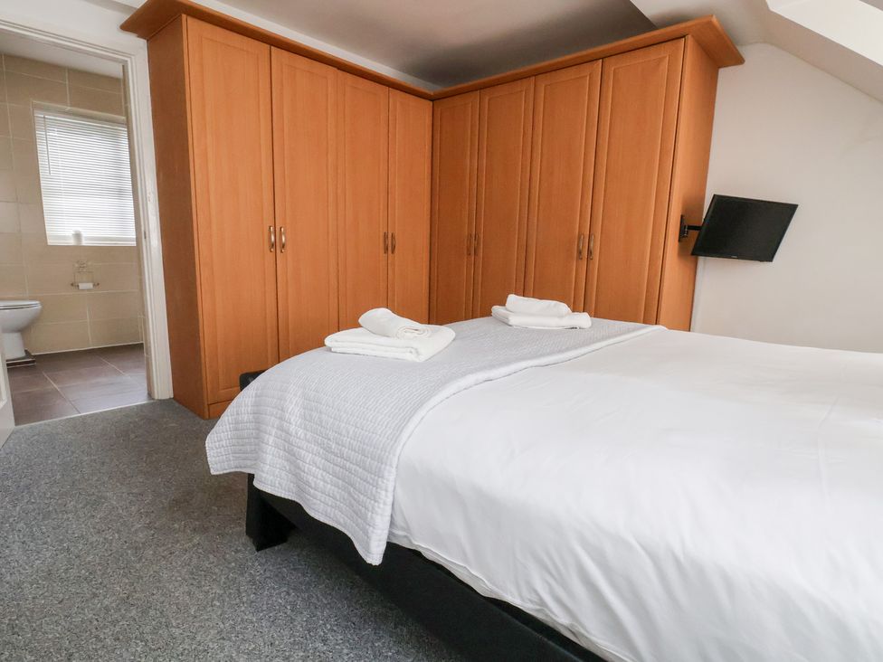 A bedroom with a bed and wardrobe at Talgais in Llangollen