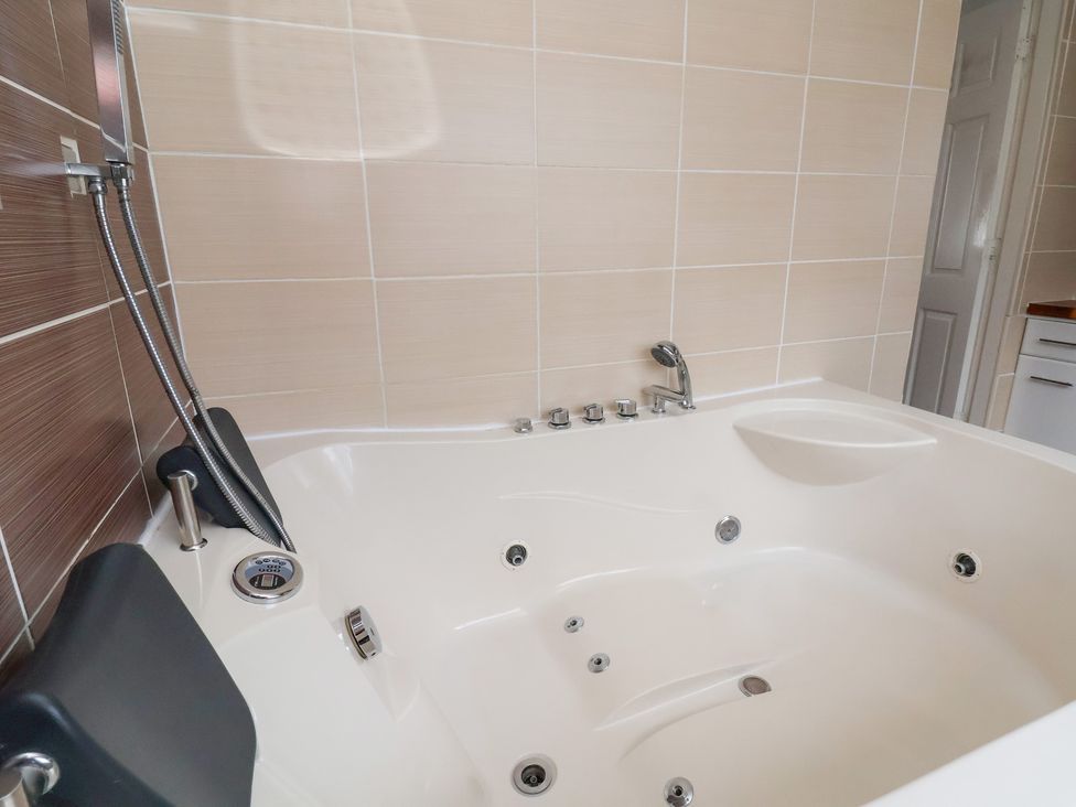 A bathtub with a faucet and showerhead in Talgais Llangollen