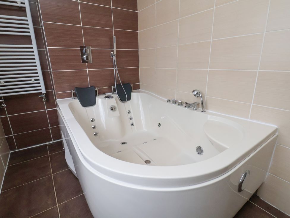 A bathroom with a bathtub and shower fixtures at Talgais in Llangollen