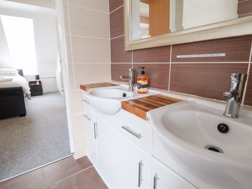 A bathroom with double sink and a mirror at Talgais in Llangollen