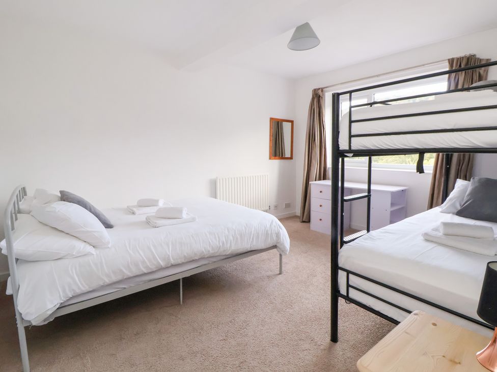 A bedroom with a bed and bunk bed at Talgais in Llangollen