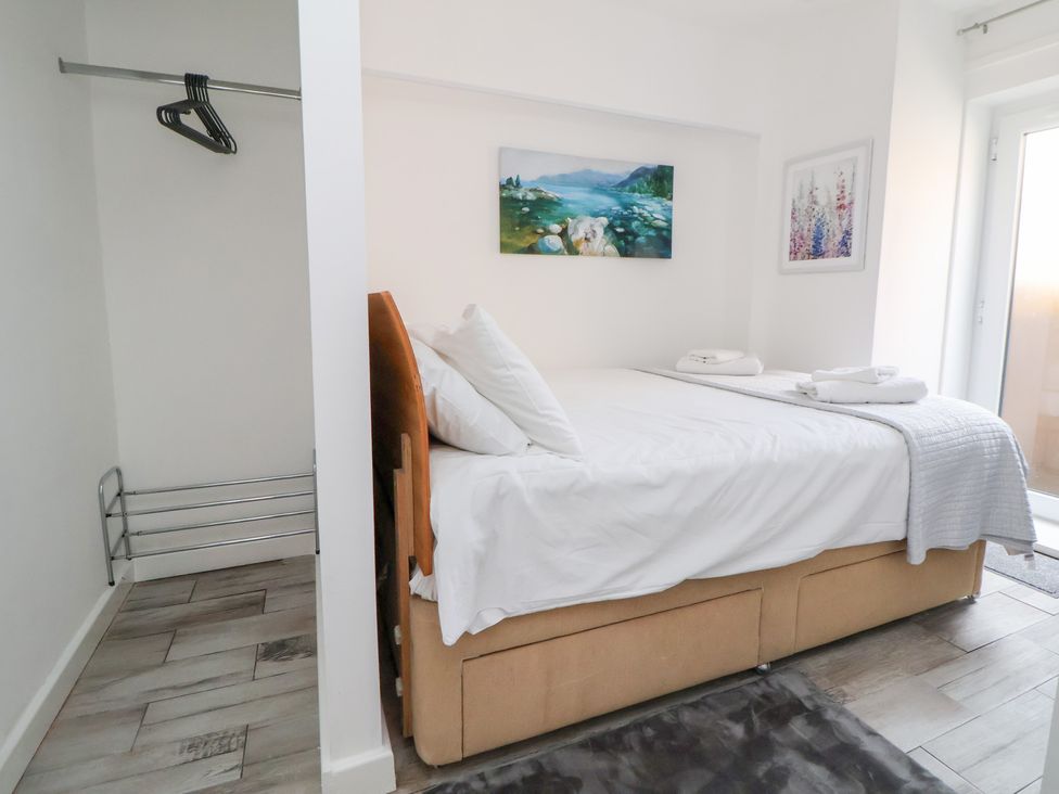 A bedroom with a bed and wardrobe at Talgais in Llangollen