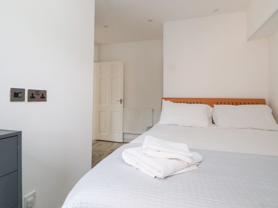 A bedroom with a bed and towels at Talgais in Llangollen