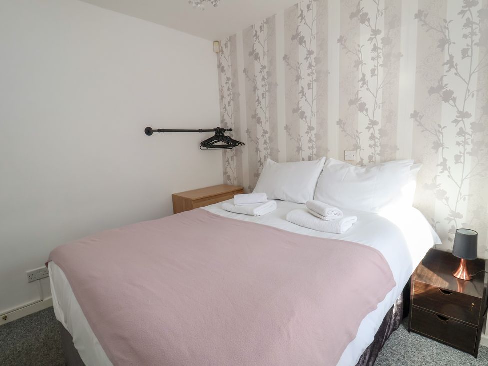 A bedroom with a bed and towels at Talgais in Llangollen