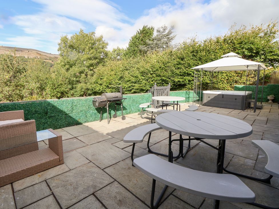 A patio area with seating and a grill at Talgais in Llangollen