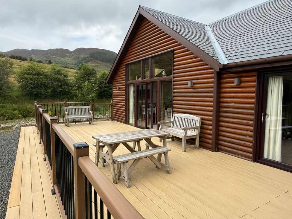 An outdoor area with a deck and seating at Burnside Lodge (Lodge 1, Glengoulandie) Aberfeldy