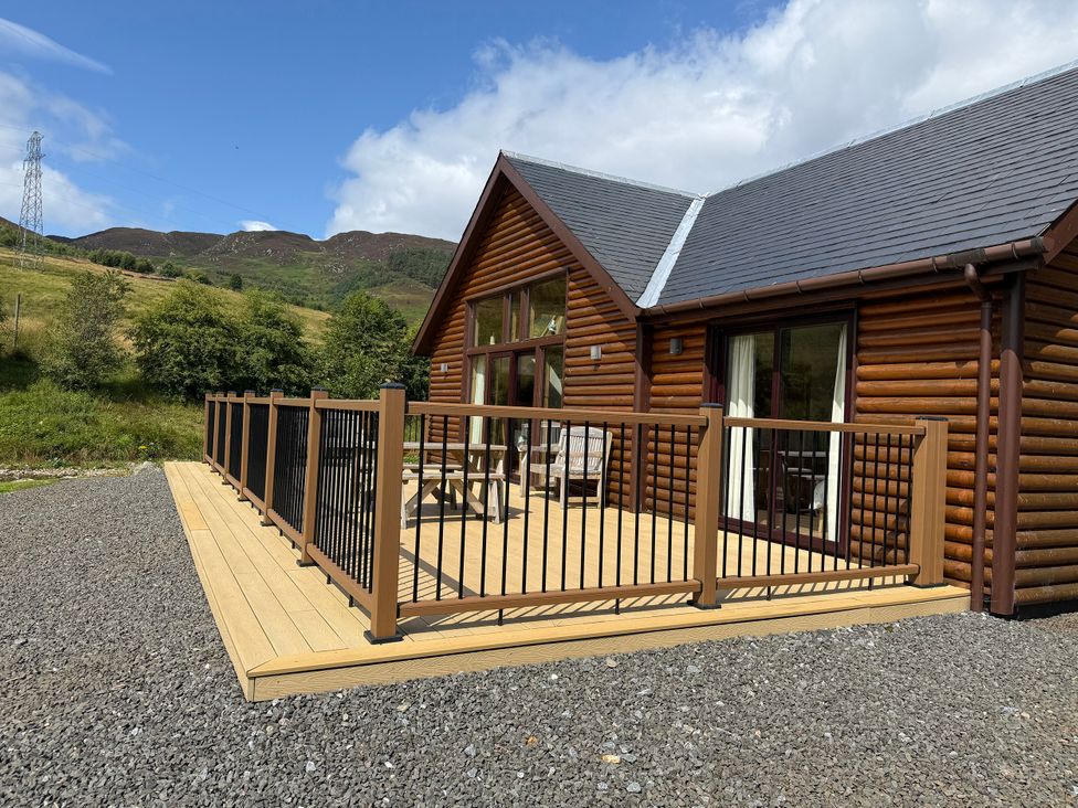 A log cabin exterior with a wooden deck at Burnside Lodge (Lodge 1, Glengoulandie) Aberfeldy