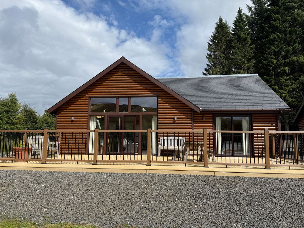 A log cabin with decking and seating area at Burnside Lodge (Lodge 1, Glengoulandie) Aberfeldy