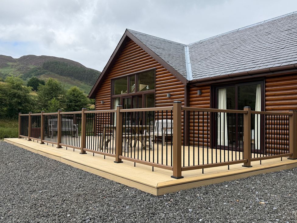 An outdoor area with decking and chairs at Burnside Lodge (Lodge 1, Glengoulandie) Aberfeldy
