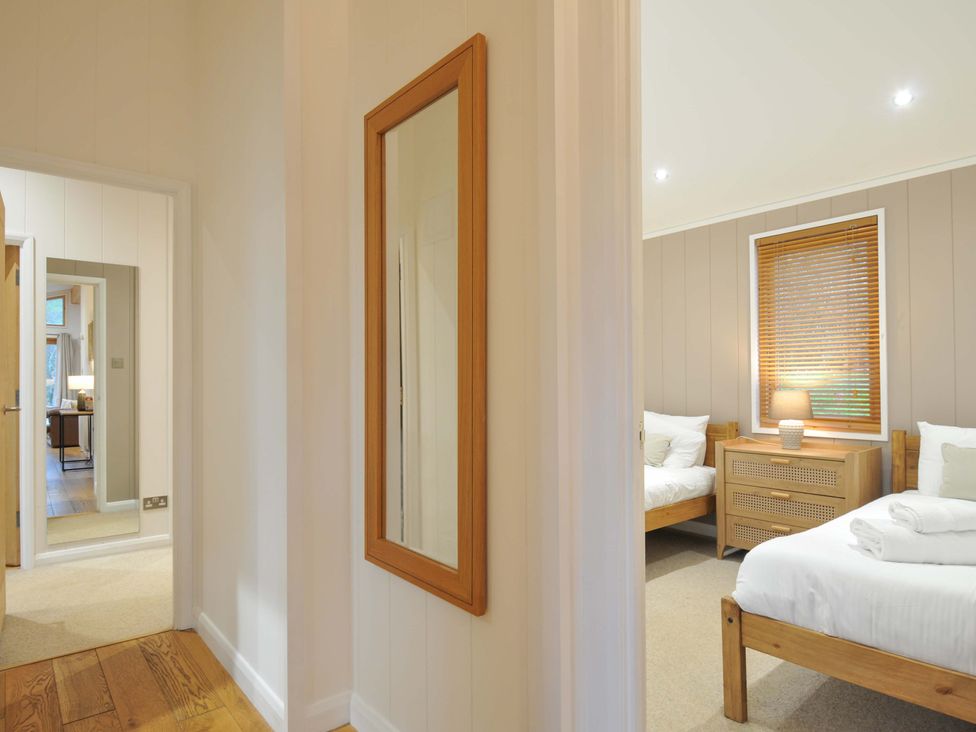 A bedroom with two beds and a lamp on a nightstand at 6 Hedgerows in Lanreath