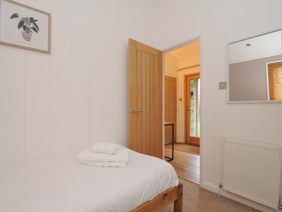 A bedroom with a bed and towels at 6 Hedgerows in Lanreath