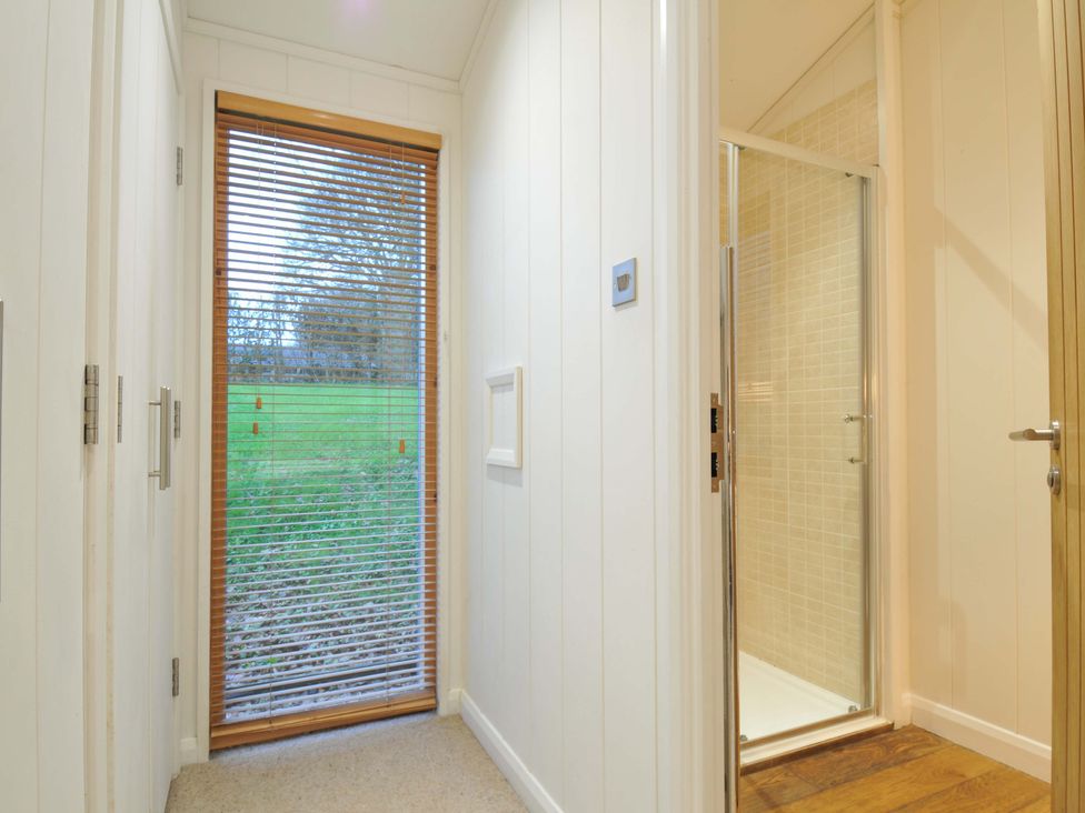 A bathroom with a shower and window at 6 Hedgerows in Lanreath